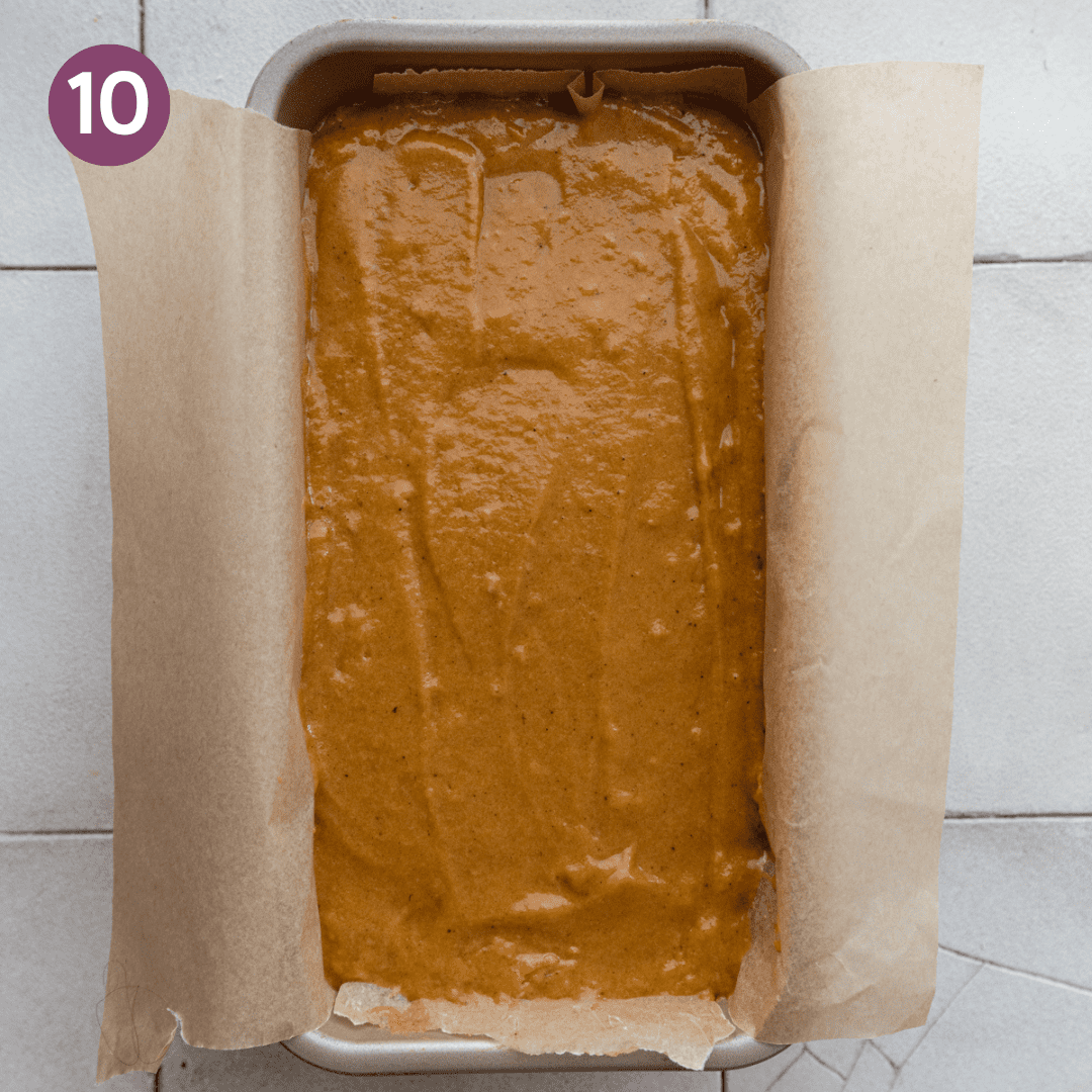 vegan pumpkin bread batter in a parchment paper lined loaf pan.