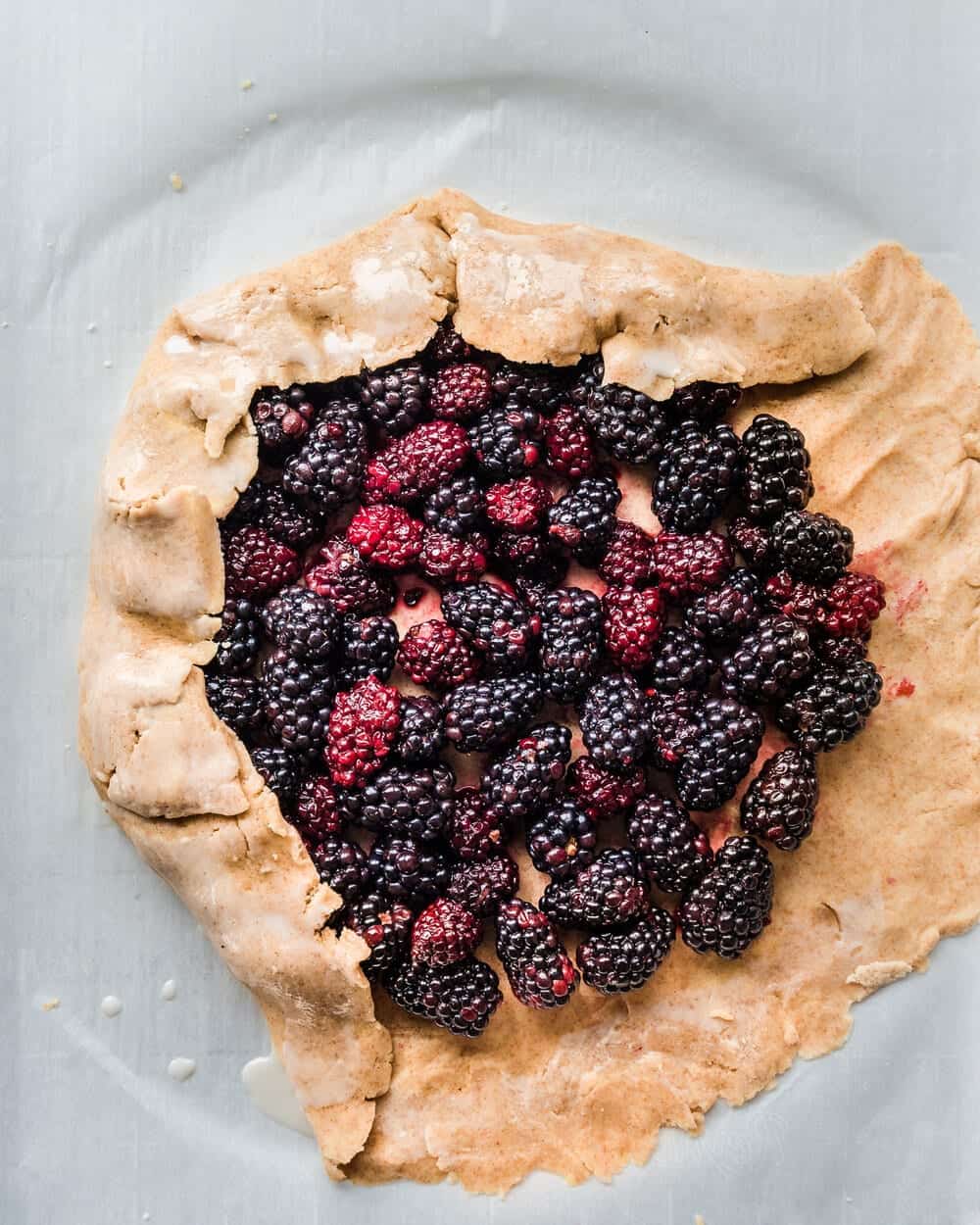 Galette dough folded over two sides of blackberries.