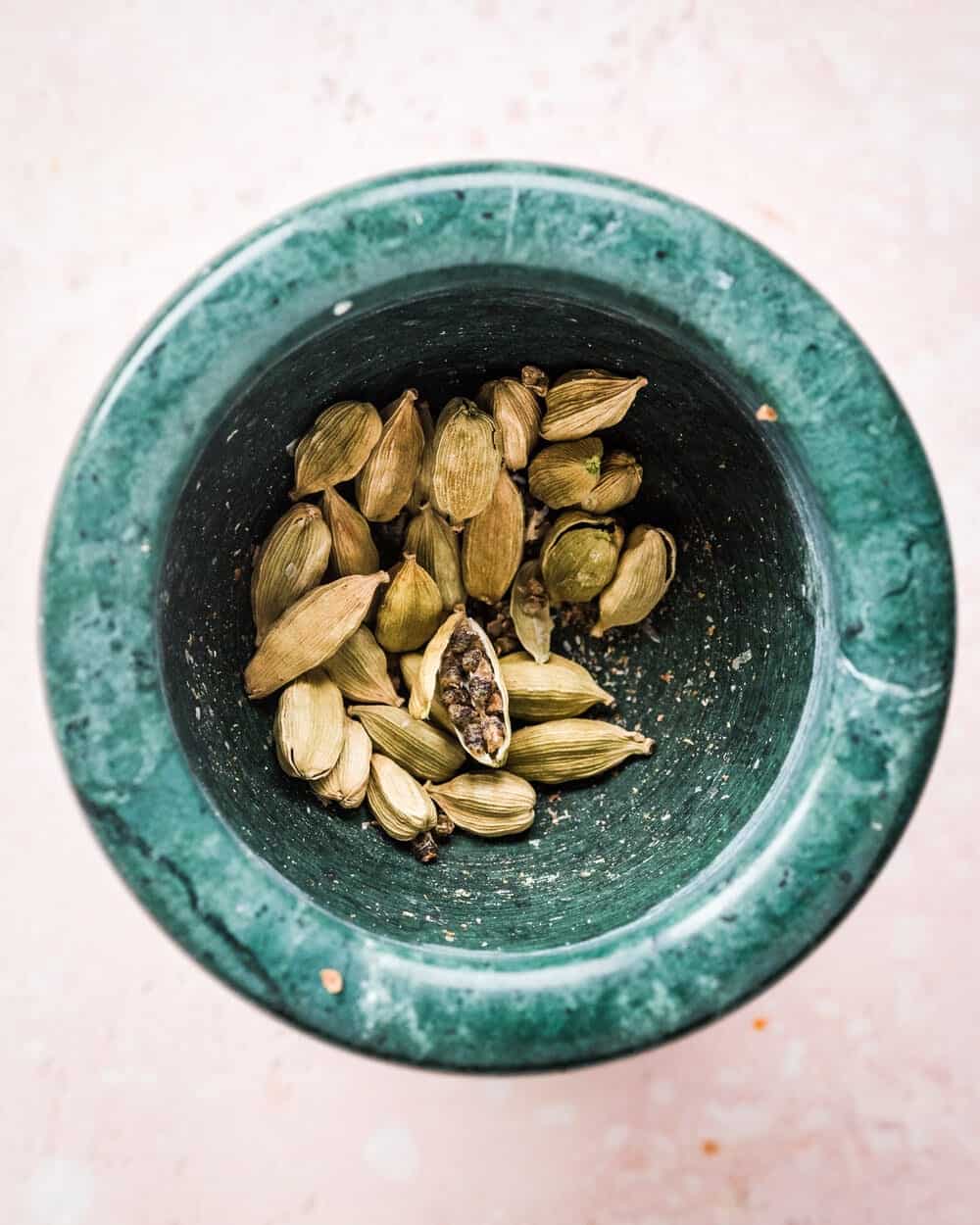 cardamom pods in a mortar bowl.