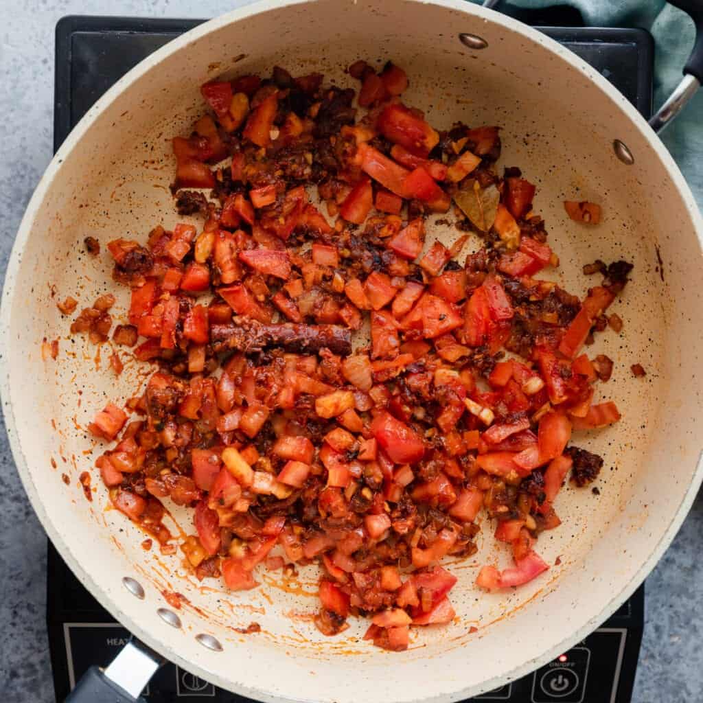tomatoes in a frying pan with onions and Indian spices