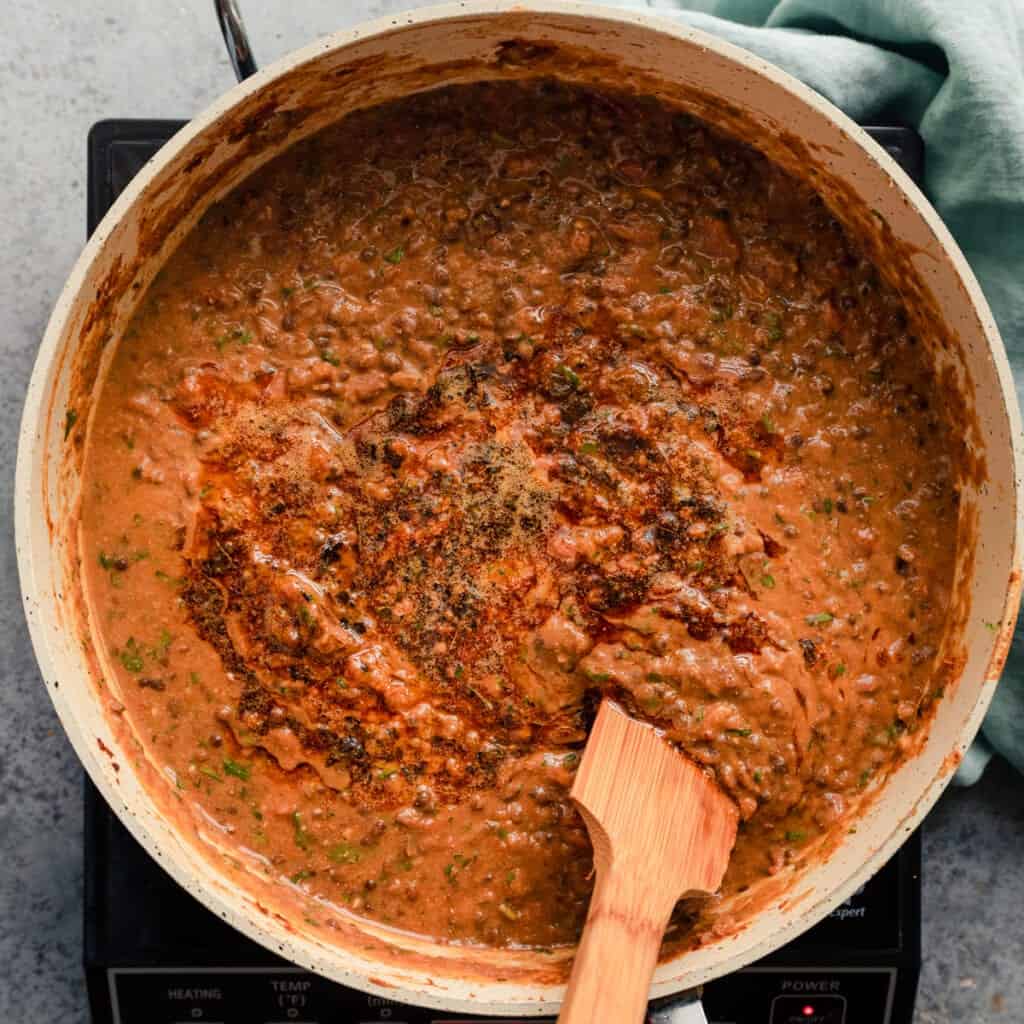 stirring tadka into vegan dal makhani