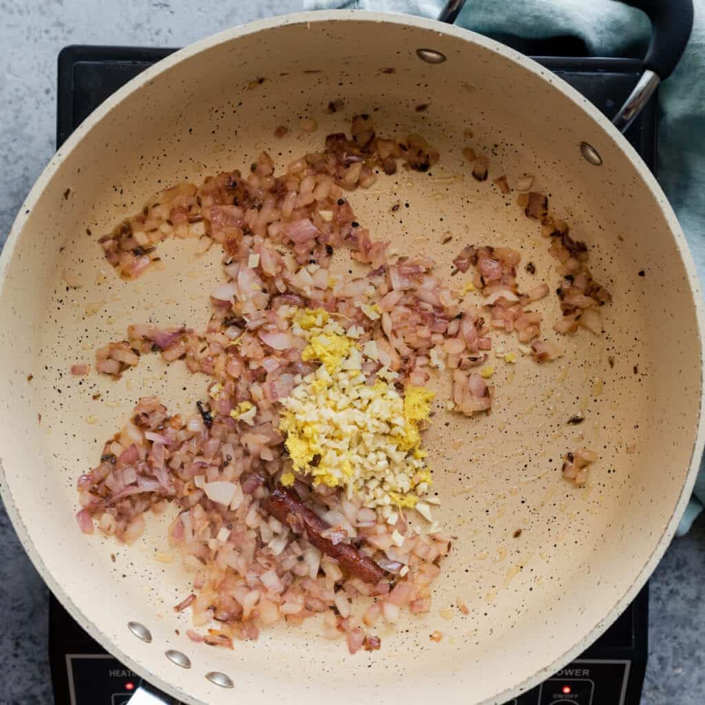 cooking onion, garlic, and ginger in a frying pan