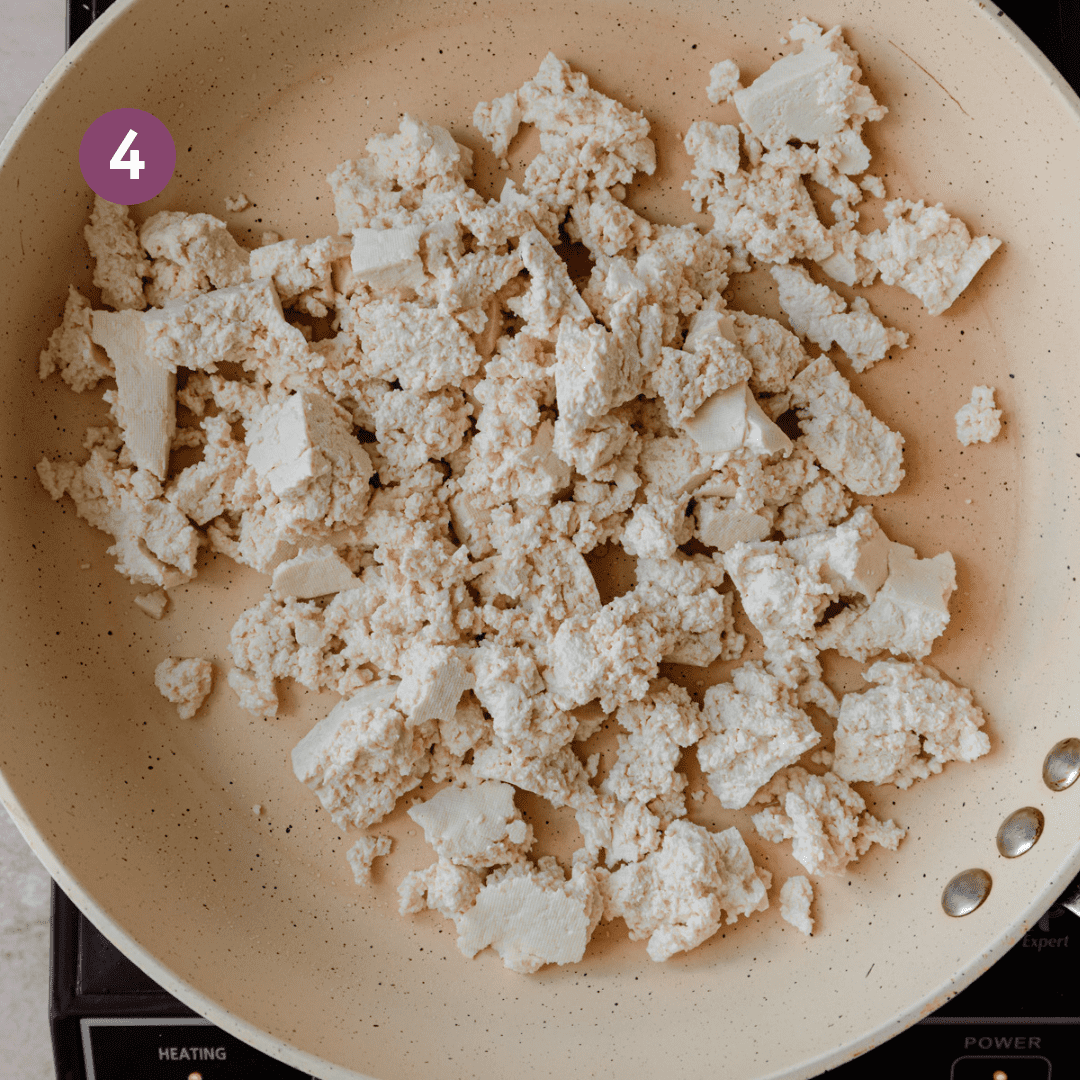 raw tofu chunks in frying pan.