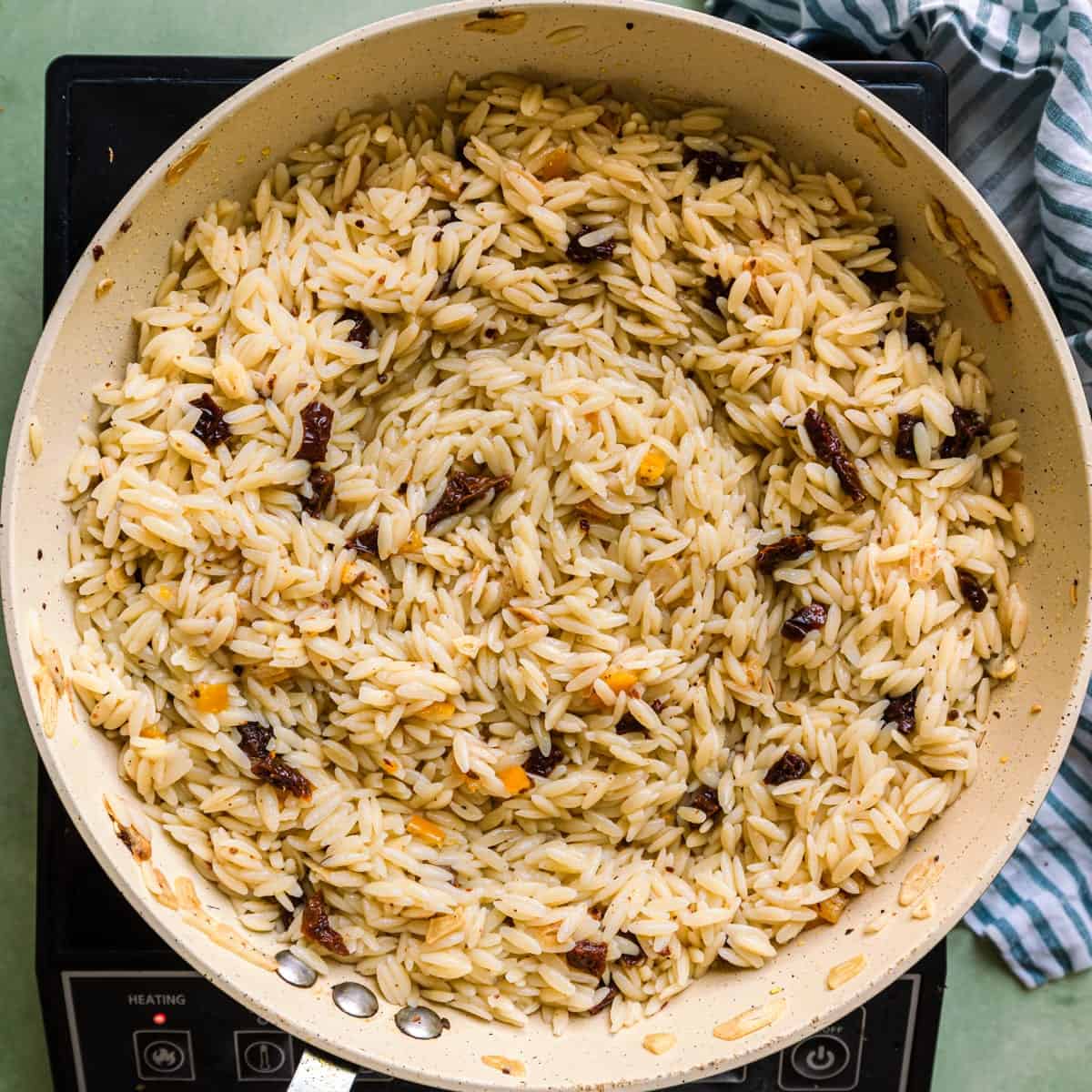cooked orzo, sundried tomatoes and preserved lemons in saute pan with olive oil and garlic.