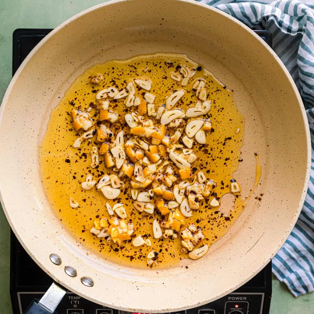 sliced garlic, preserved lemon, and chili flakes cooking in olive oil.