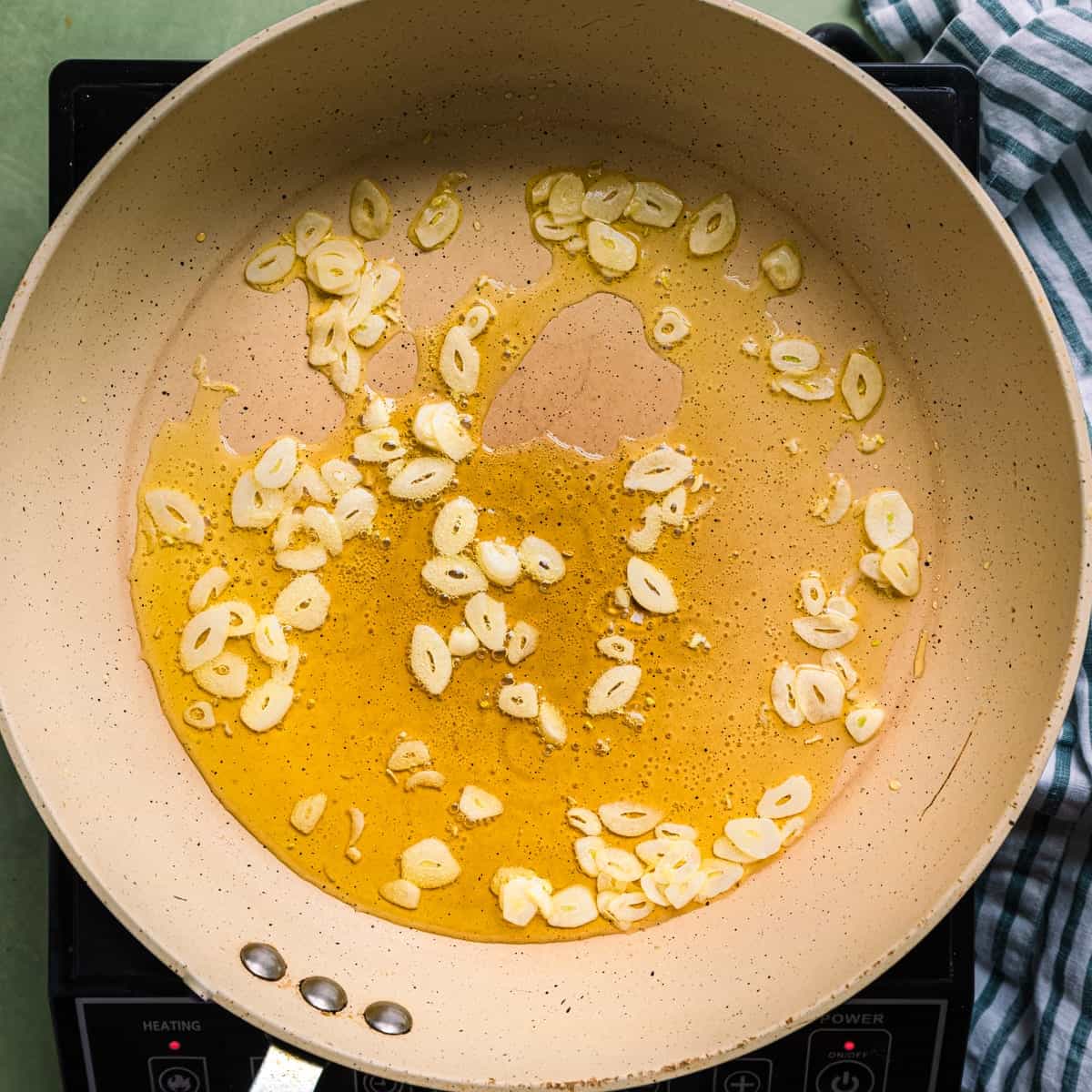 sliced garlic frying in olive oil.