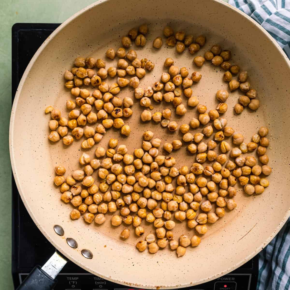 pan-frying chickpeas in a saute pan.