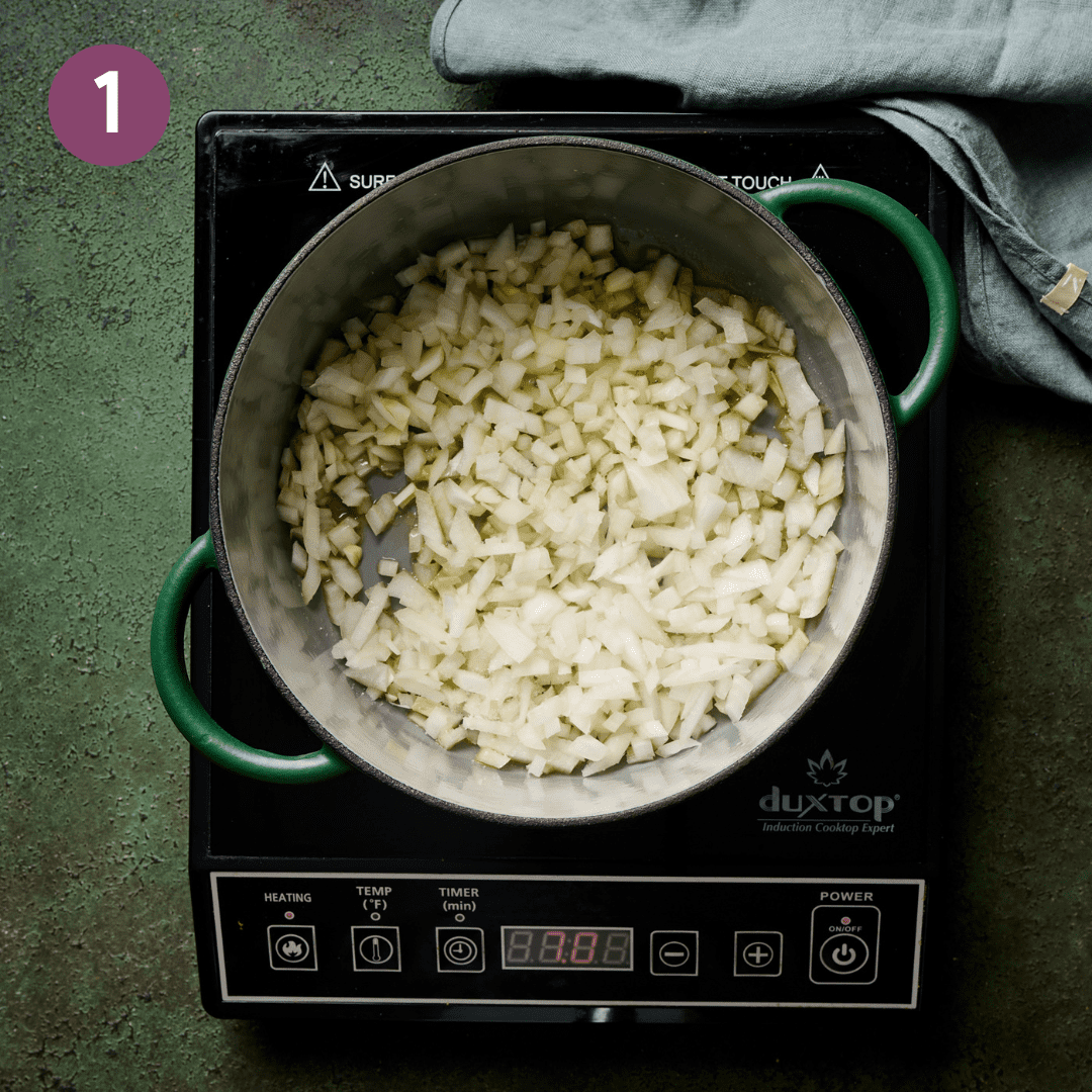 Onion and olive oil cooking in a dutch oven.