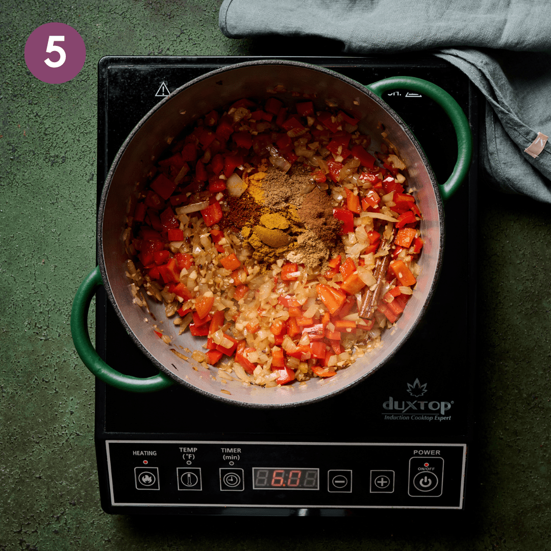 All the spices added on top of the other ingredients in the pot.