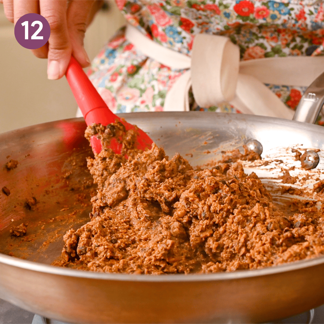 person cooking the salsa and bean mushroom mixture.