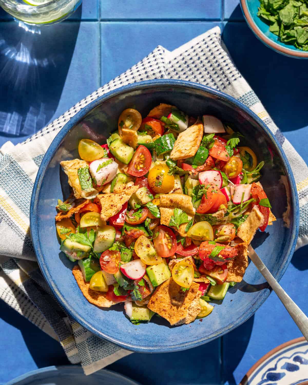bowl of fattoush on a cloth napkin on a table.