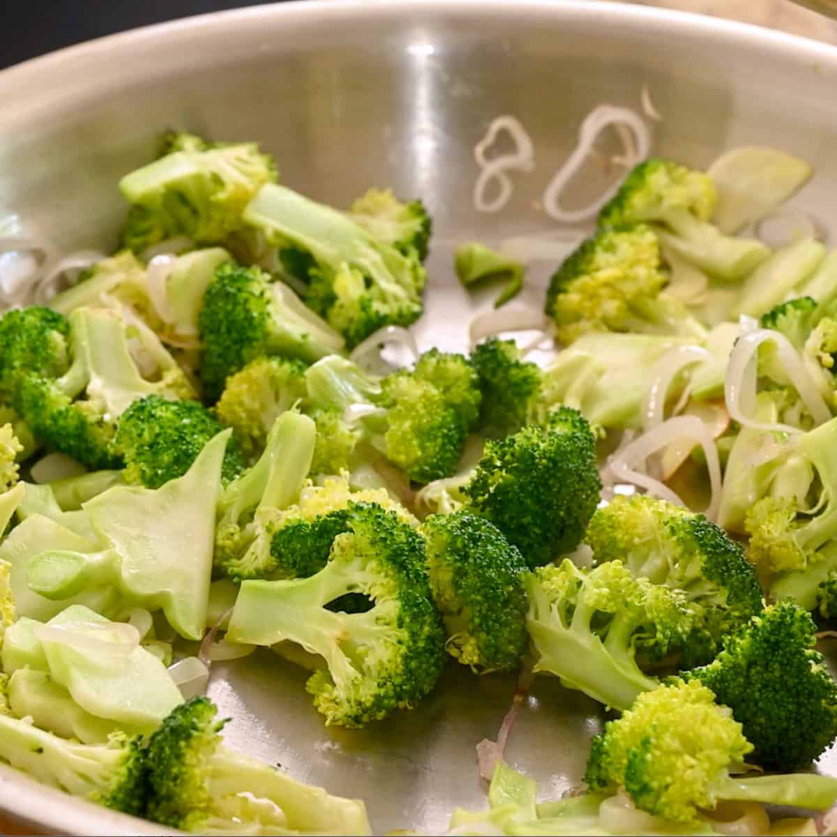 Broccoli and a pinch of salt added to the frying pan.